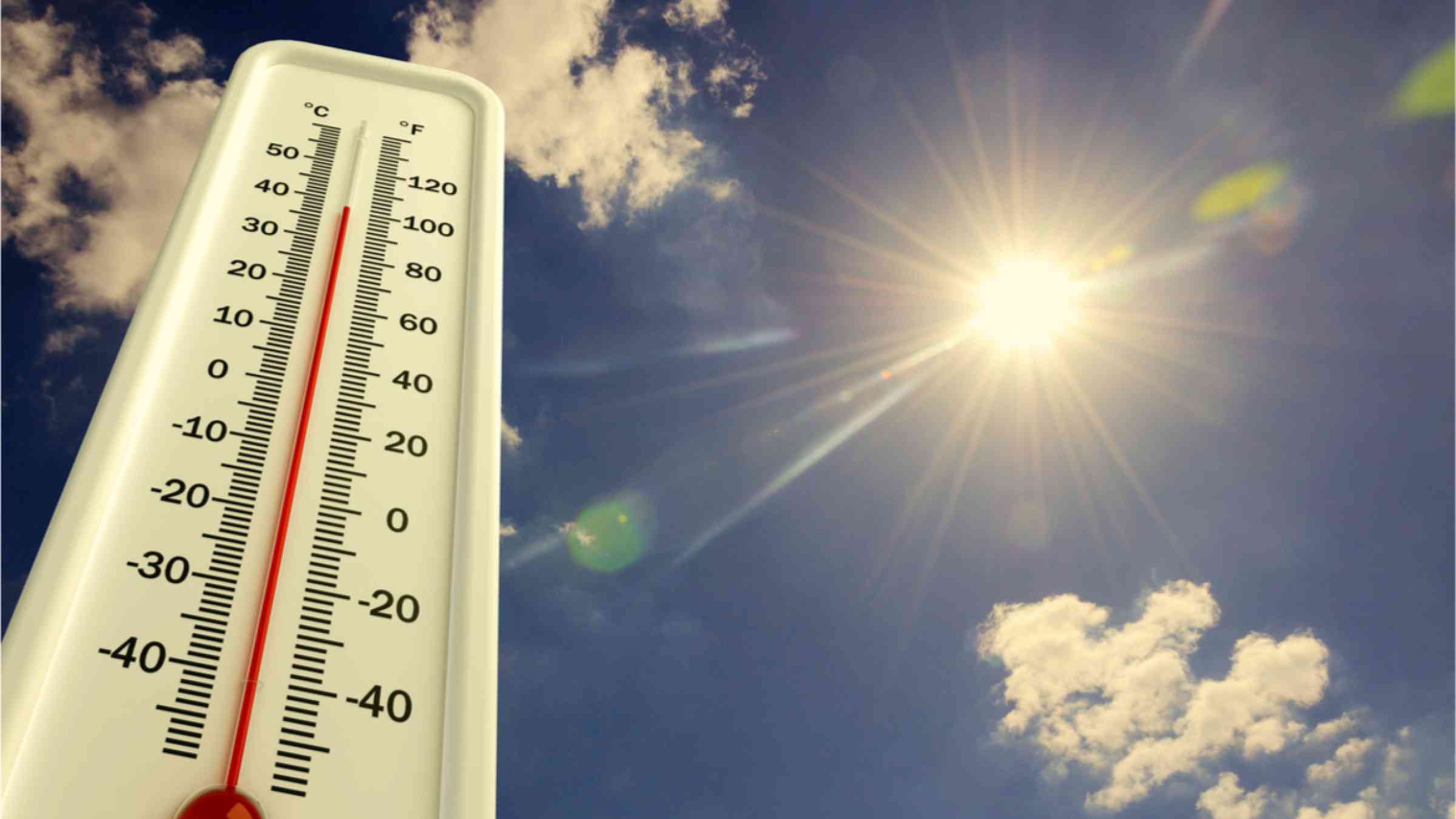 This image shows a thermometer indicating high temperatures. The sun is shining brightly in the sky.