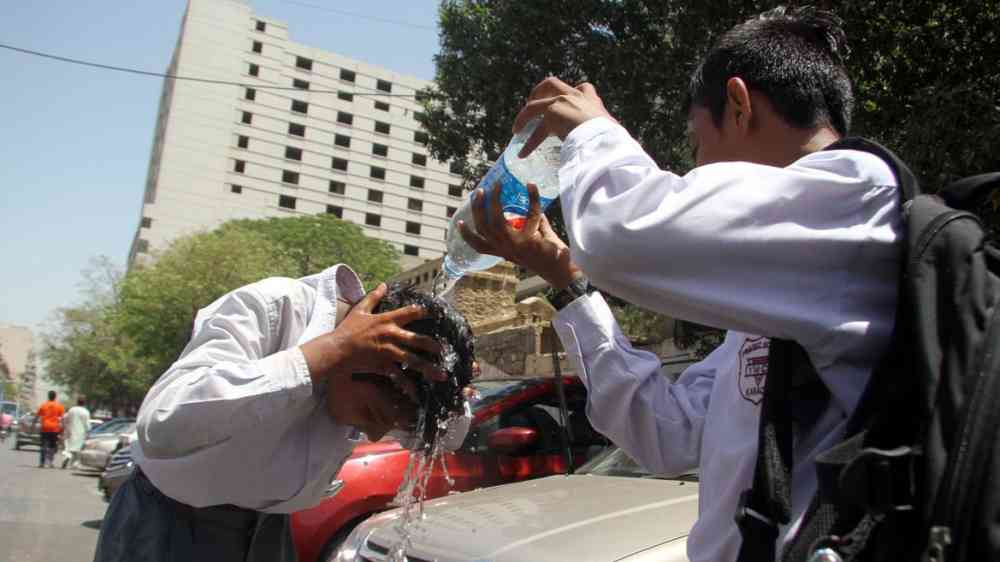 Student gets his head wet to beat the heat of scorching sun