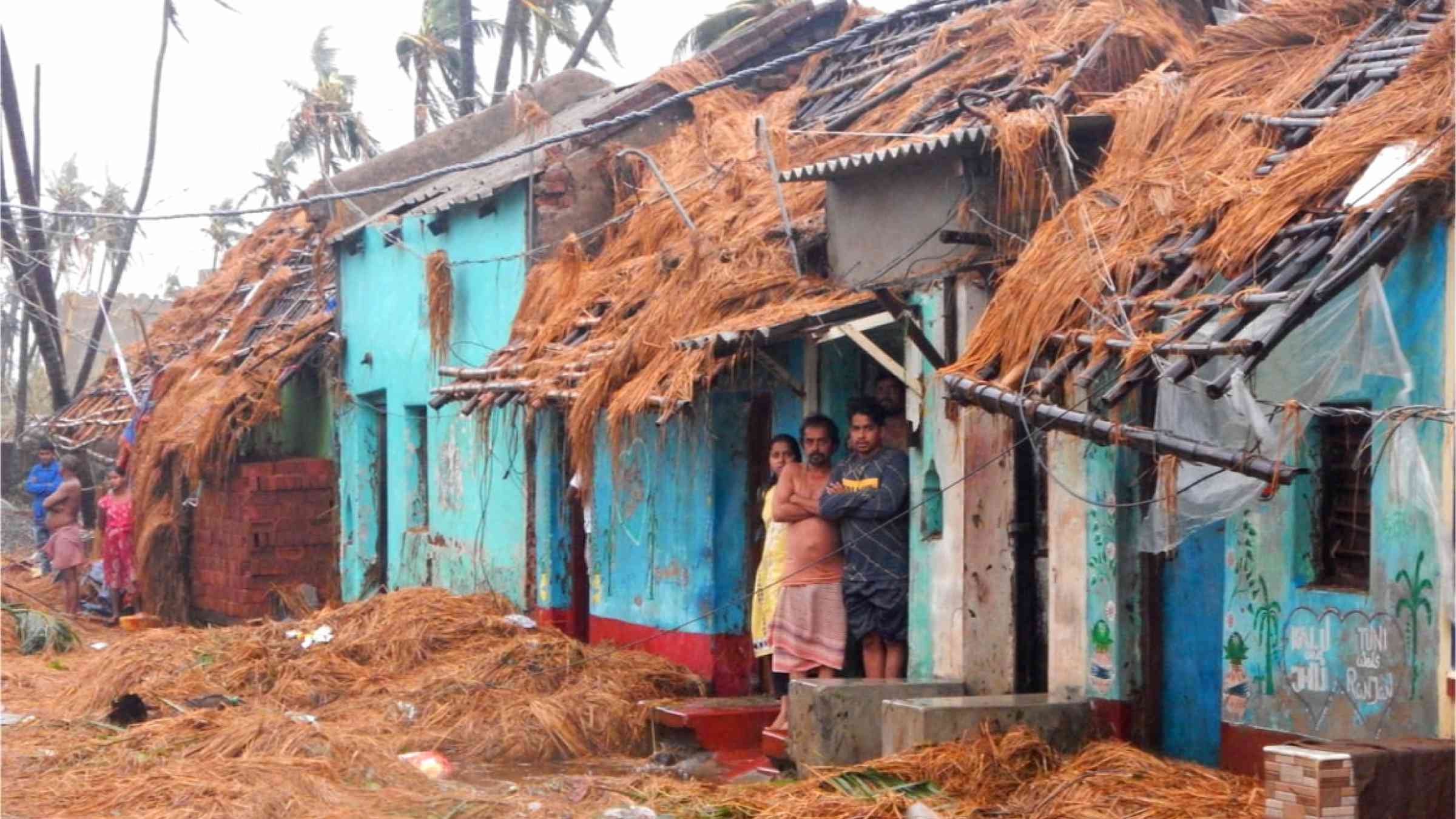 An Indian family standing outside their house after cyclone Fani devastated the neighborhood.
