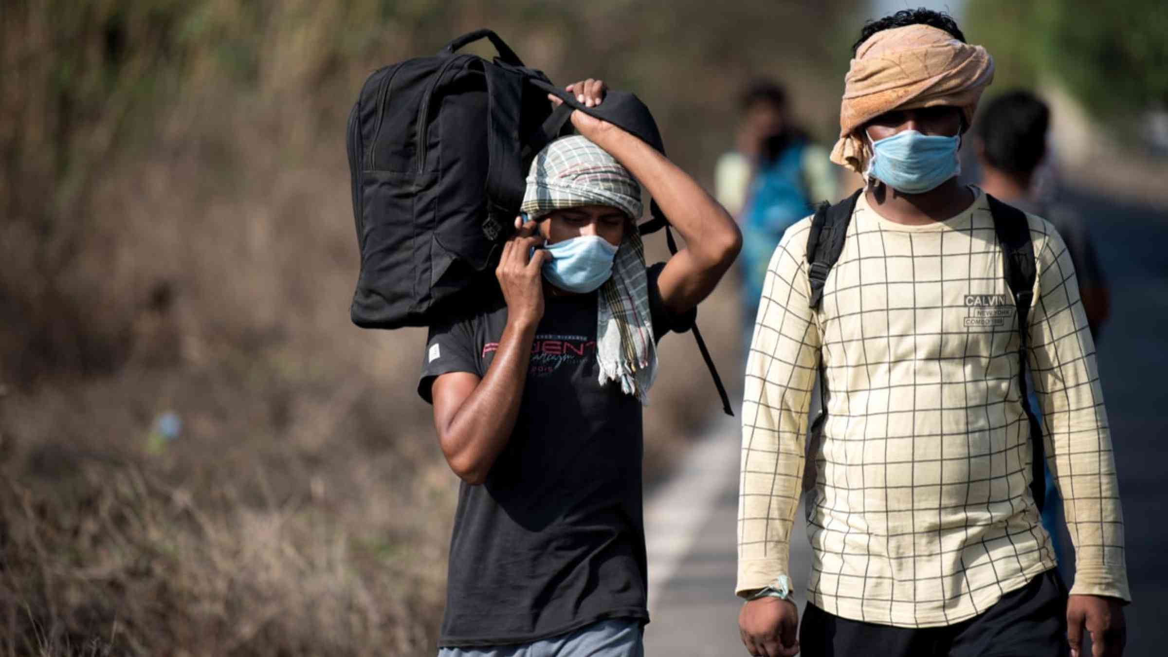 Migrant workers walk on the highway on their journey back home during a nationwide lockdown to fight the spread of the COVID-19 coronavirus in Mumbai, India (2020)