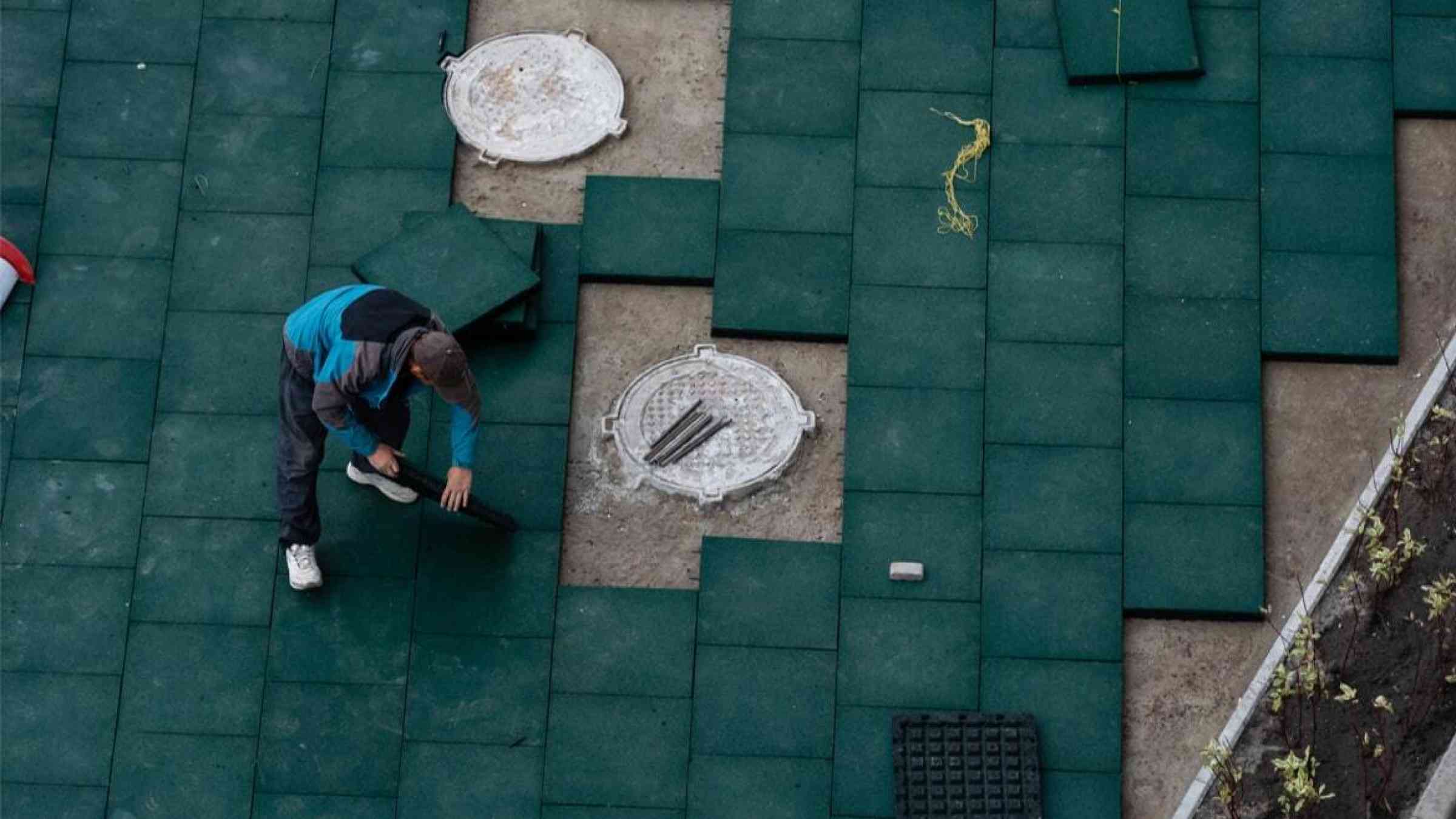 Aerial view of a worker laying tiles