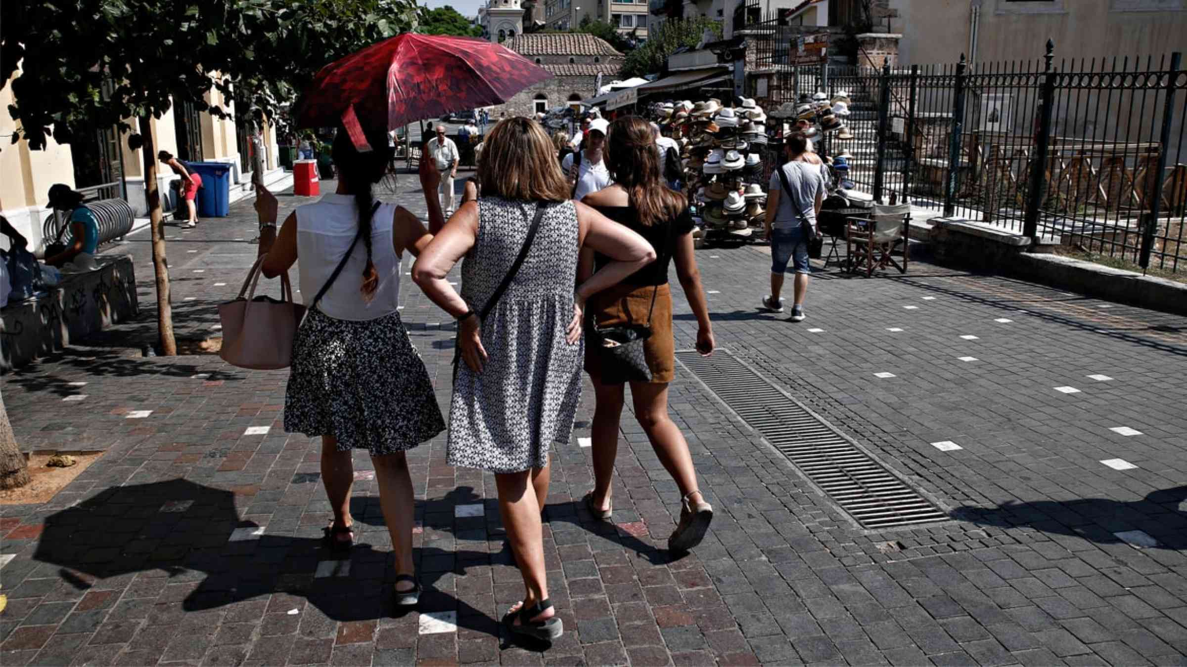 People walk in the street of central Athens during a heatwave in Athens, Greece (2017)