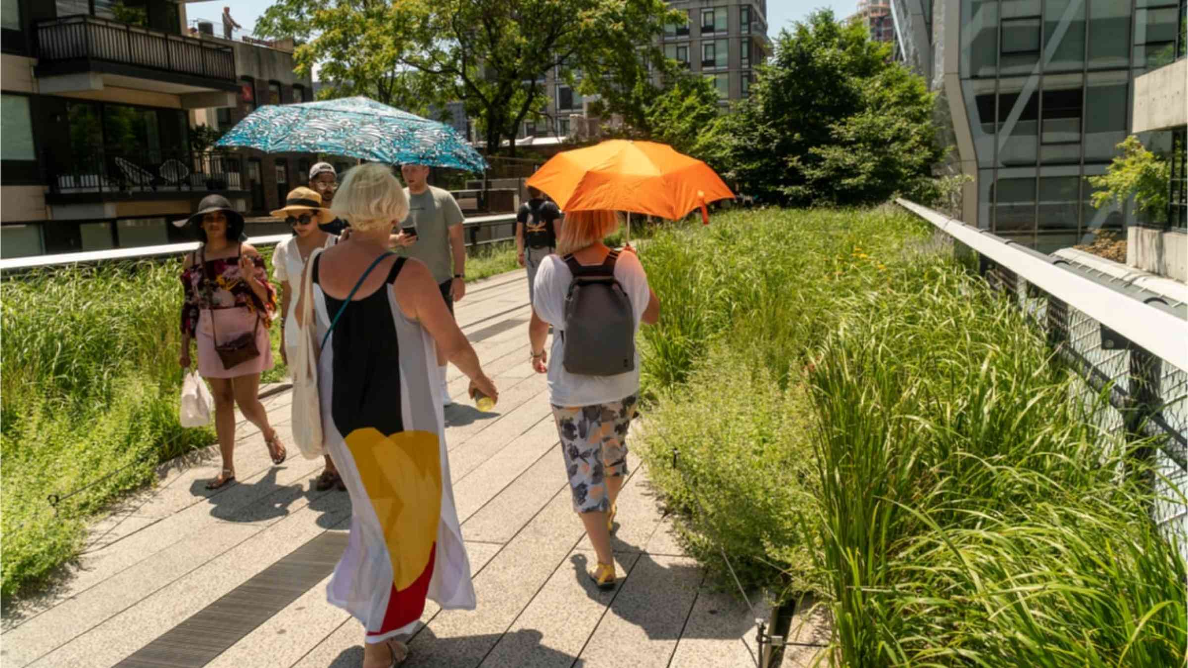 People carrying umbrellas to protect themselves from the sun and heat in the USA.