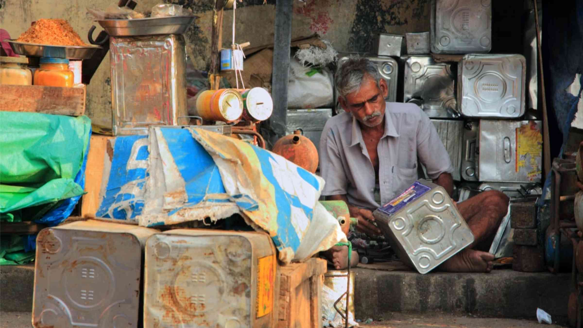 Unidentified street vendor works with reused tin containers at Port Blair, India (2012)