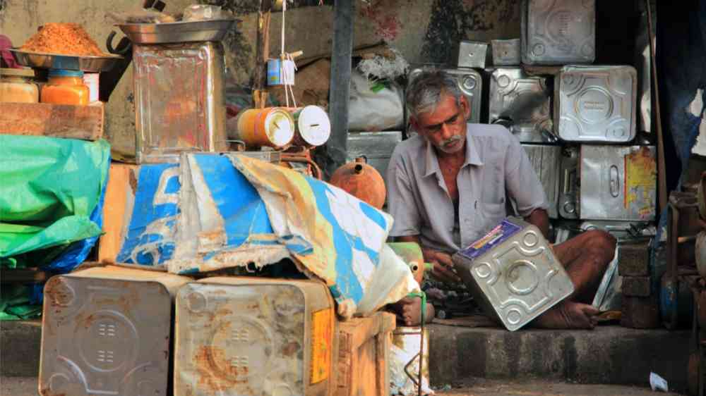 Unidentified street vendor works with reused tin containers at Port Blair, India (2012)