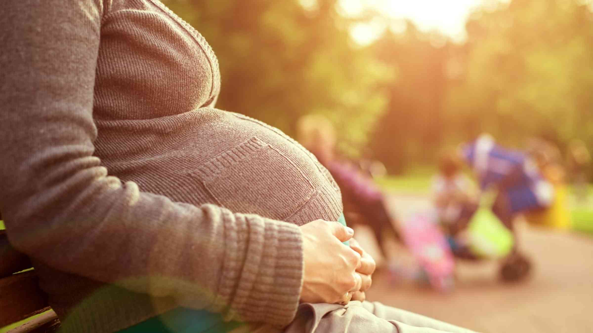 Pregnant woman sitting on a bench