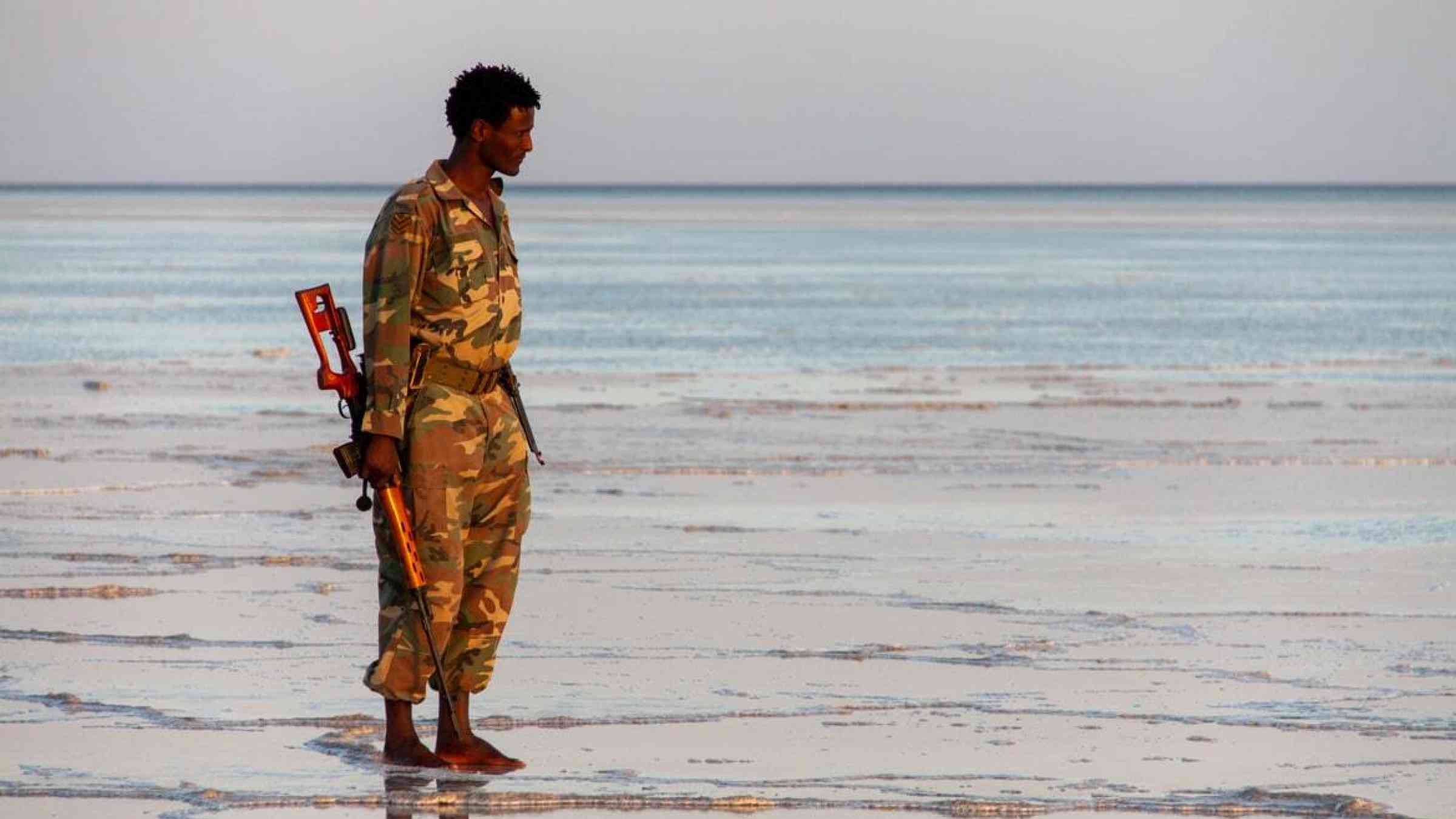Ethiopian soldier standing at a lake shore