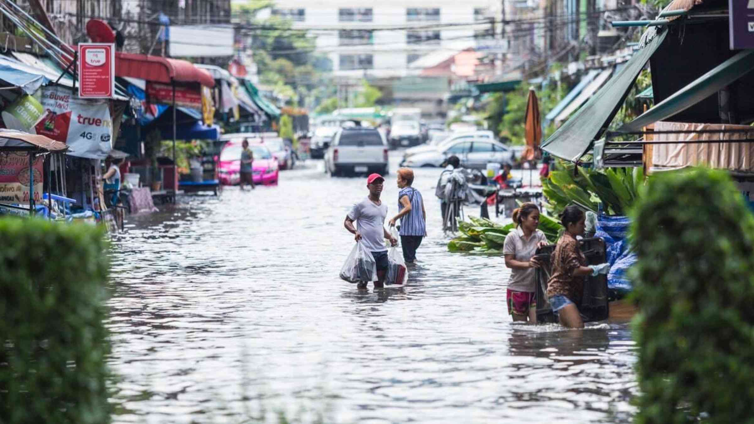 Bangkok residents wade floods after heavy rains left the city inundated