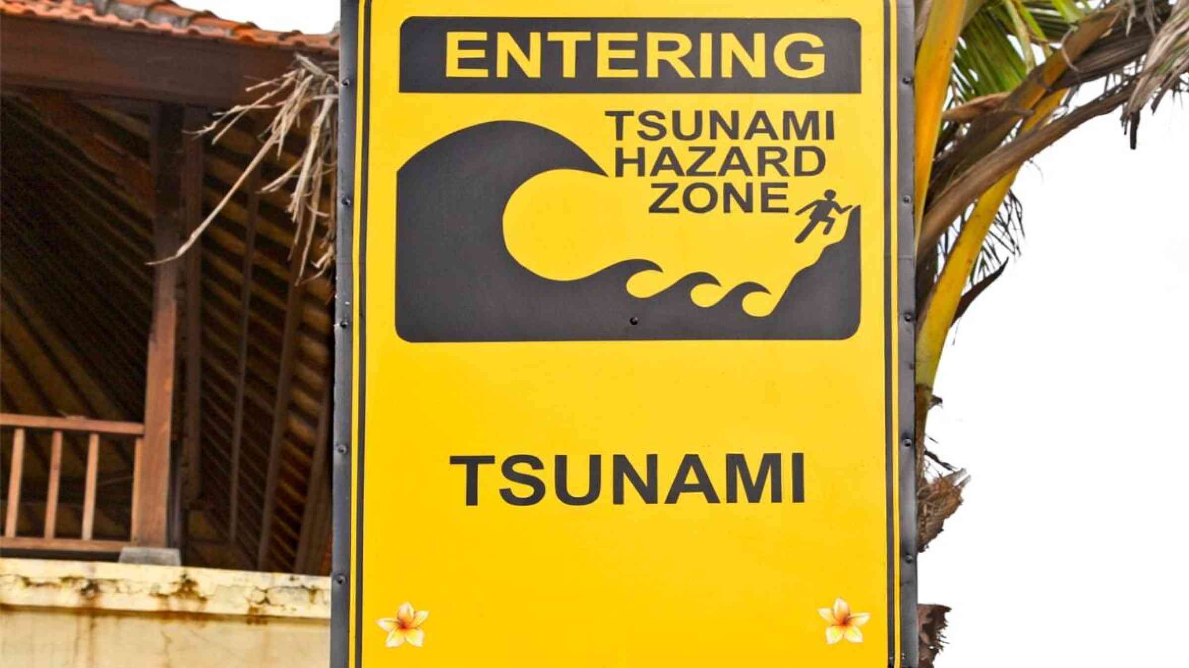 Yellow tsunami hazard zone warning sign in Bali, Indonesia
