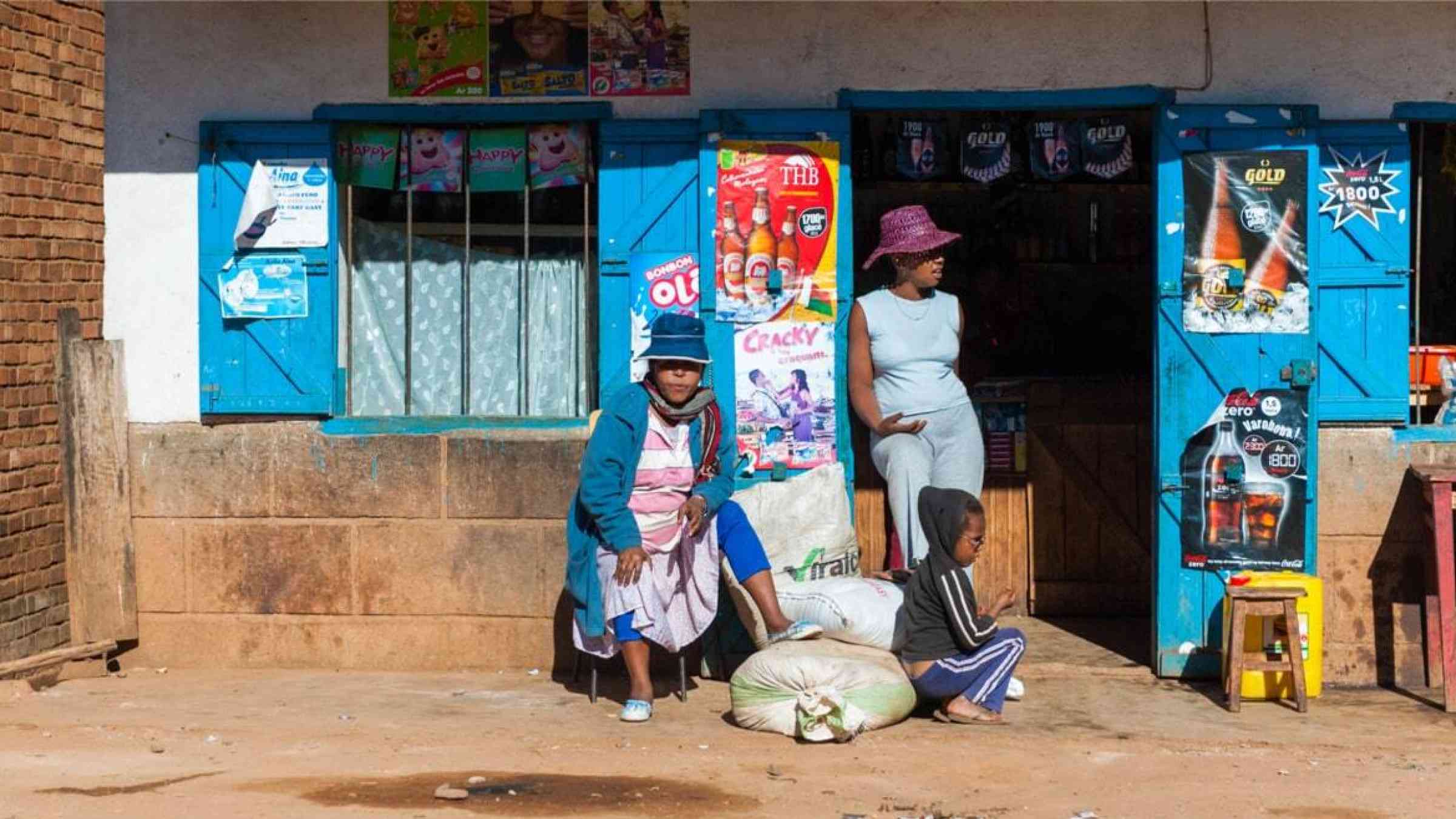 Women and child standing in front of a grocery shop in Madagascar