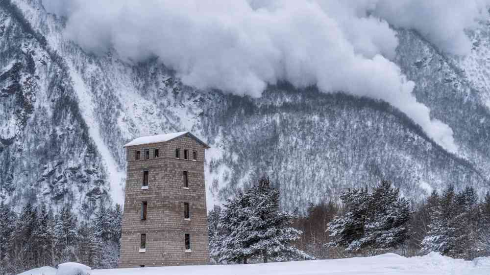 Avalanche on a mountain close to a building