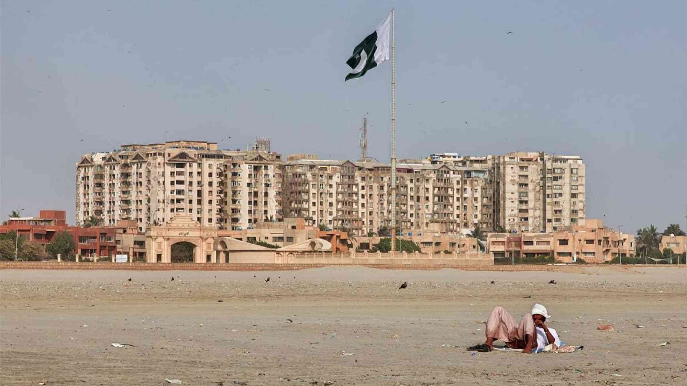 A man lies down on Clifton beach in Karachi, Pakistan
