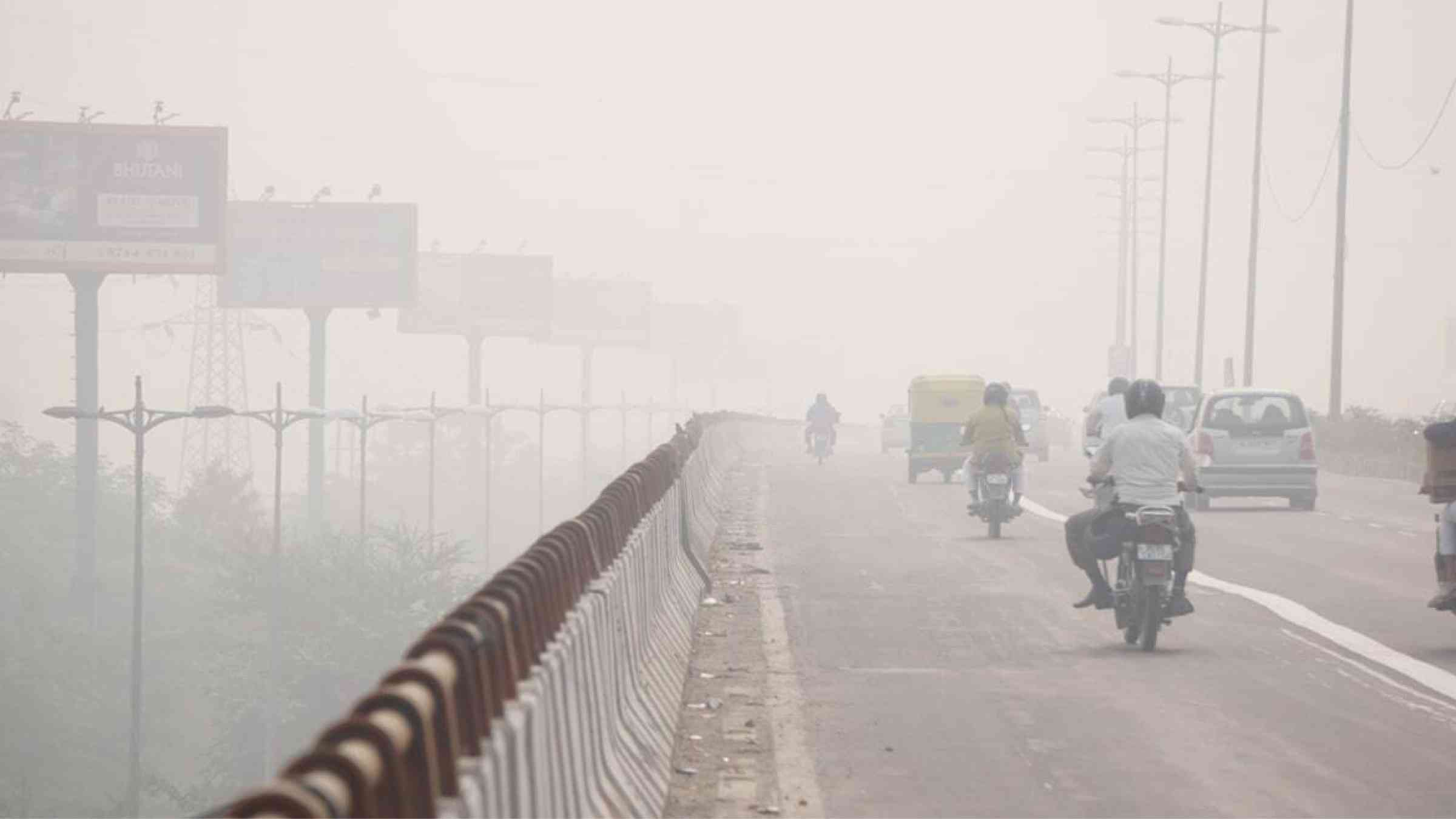 Motorists drive along heavy smog in Delhi, India