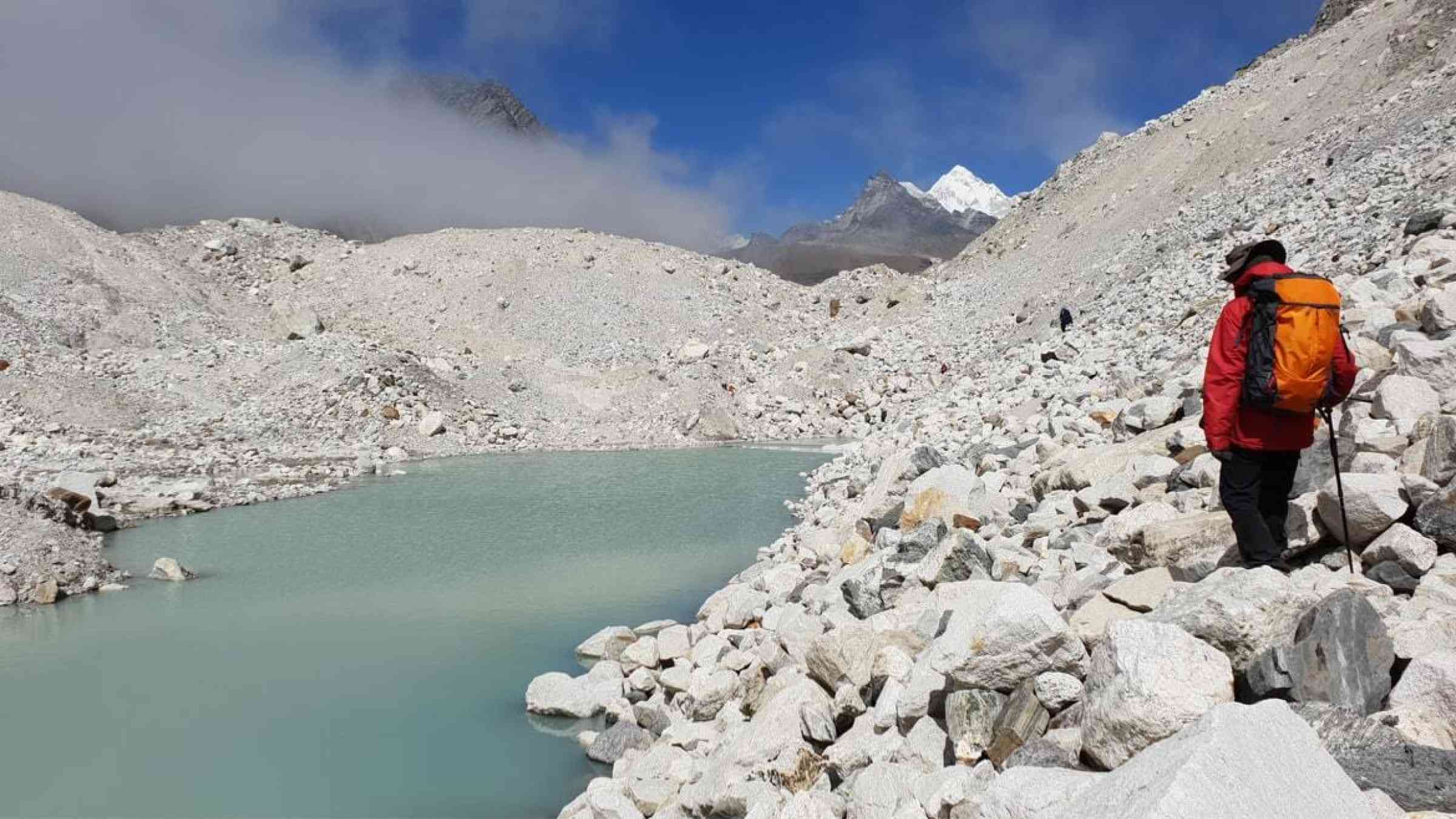 A man treks the banks of a lake high up Nepal near Mt. Everest