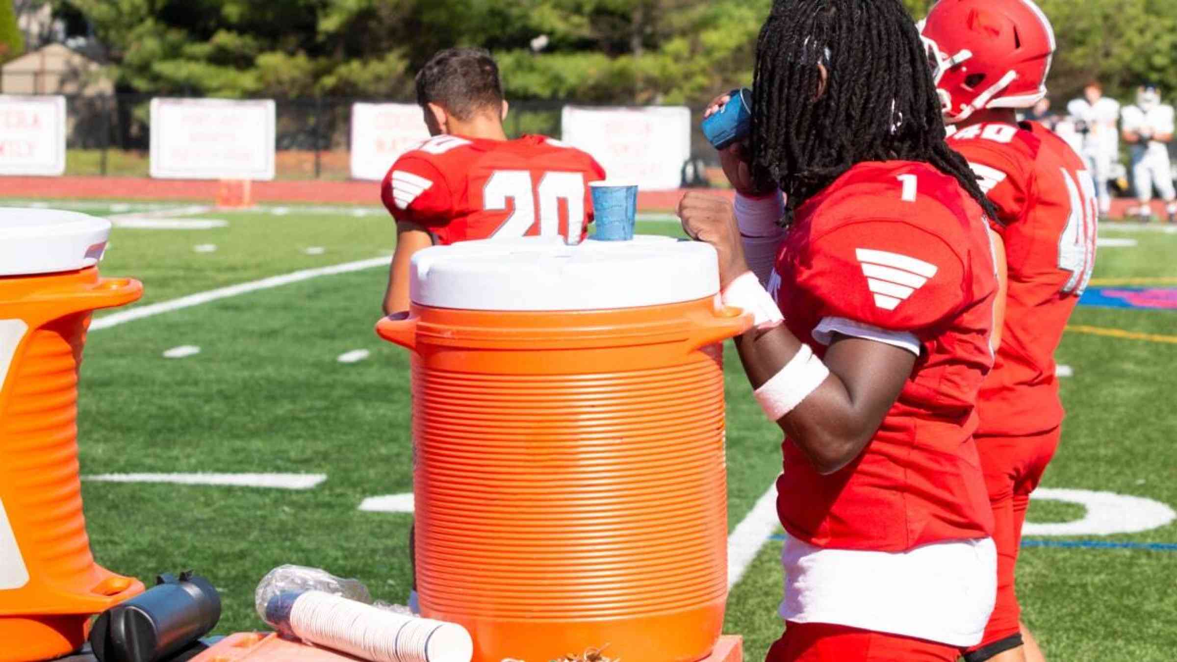 A football player takes a water break in between matches