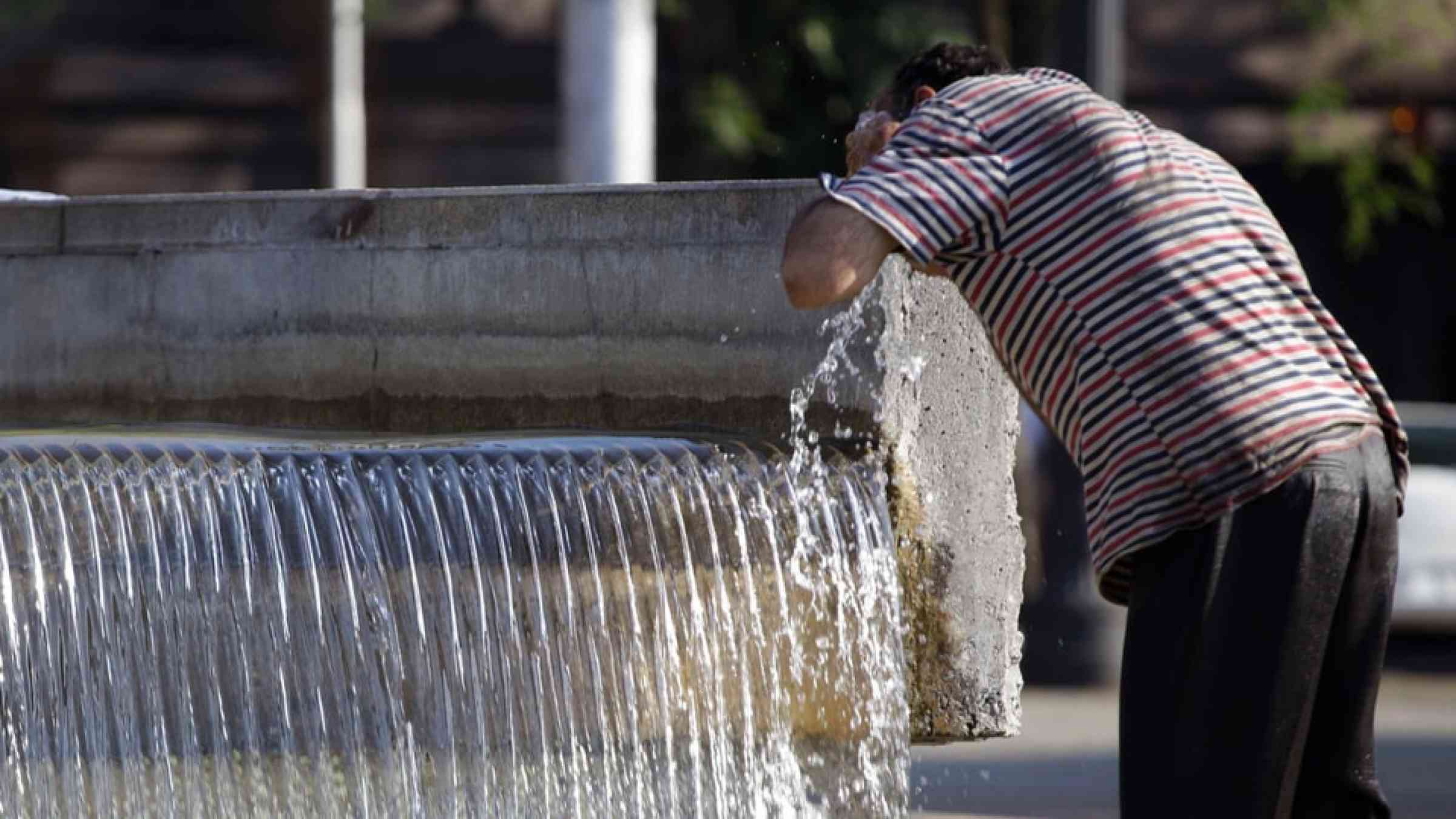 A homeless man washes himself in a public water fountain in Se square, downtown Sao Paulo, Brazil