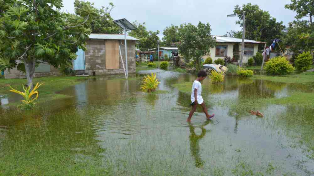 Indigenous Fijian girl walking on flooded land in Fiji