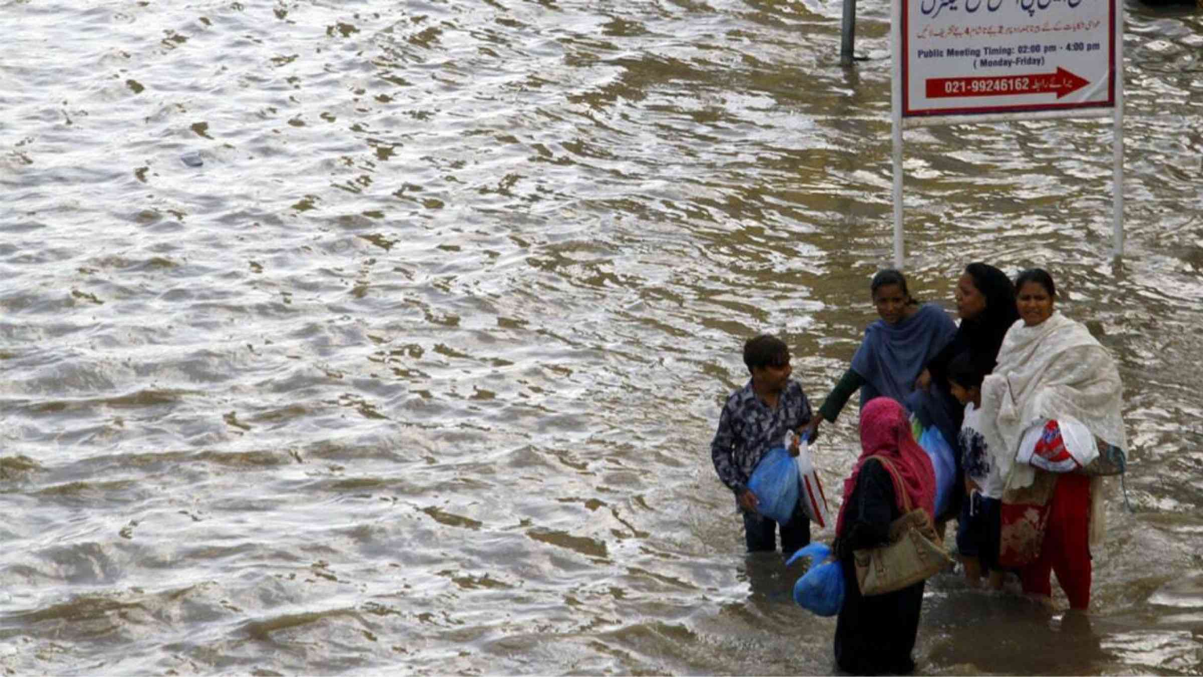 A group of pedestrians are stranded during heavy flooding in Karachi, Pakistan