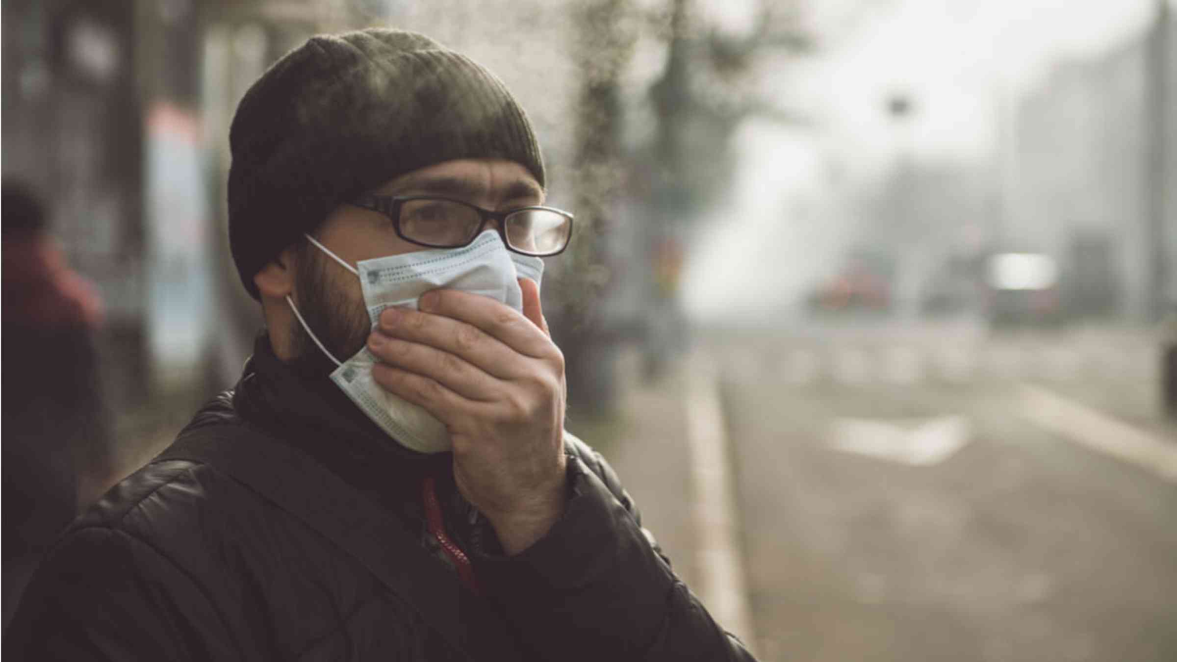 Man covering face from air pollution