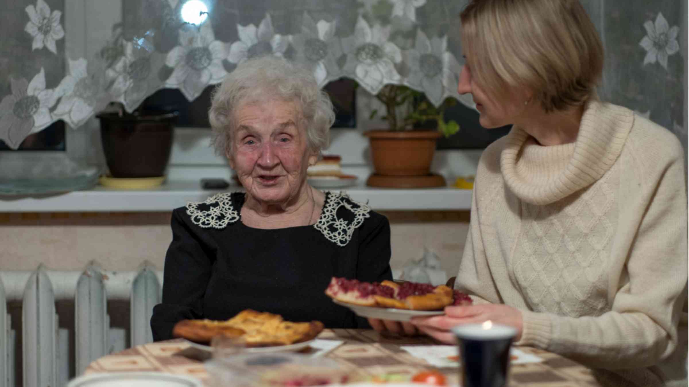 An older woman enjoys dinner with her daughter