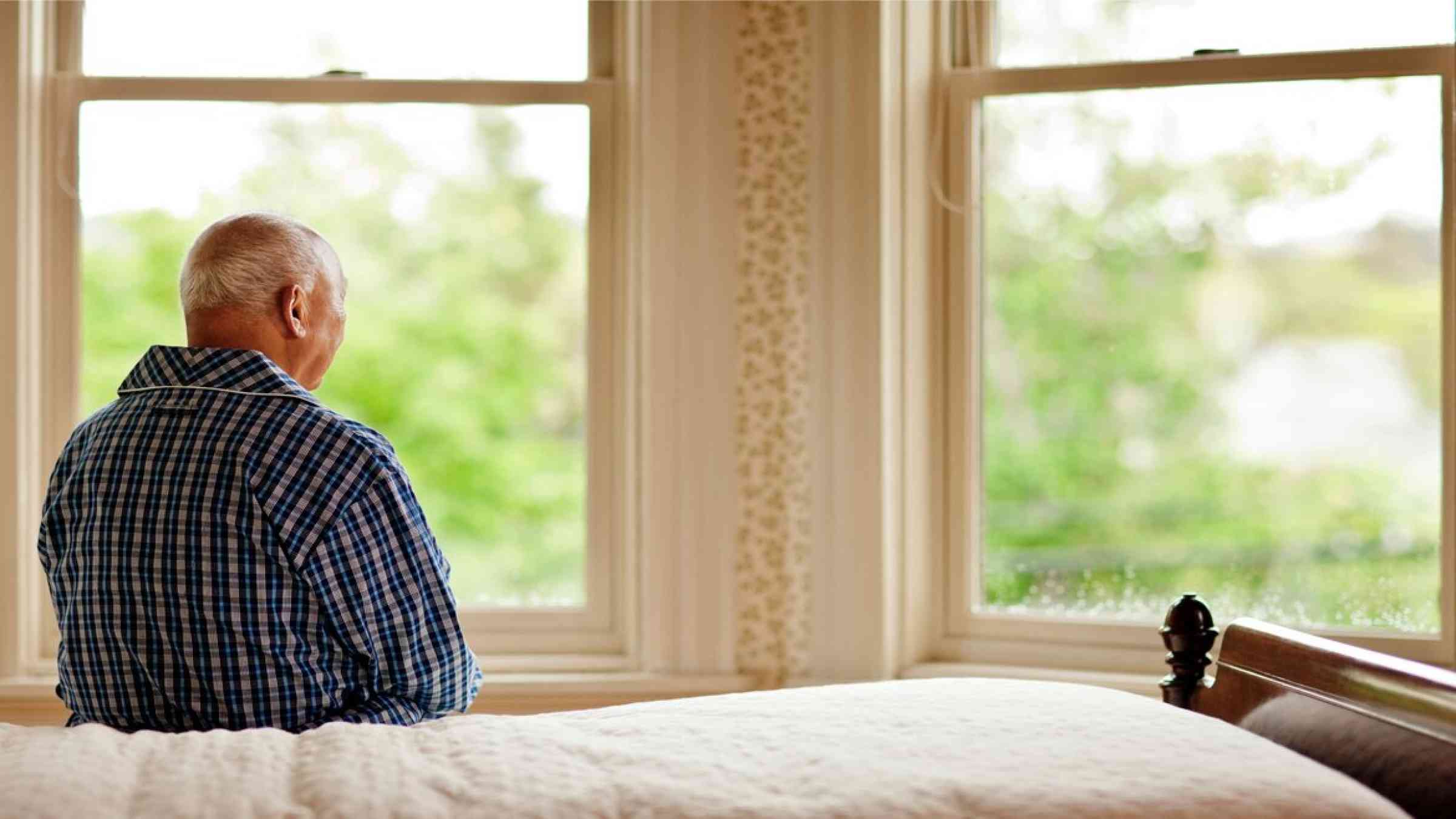 Senior man looking out his window