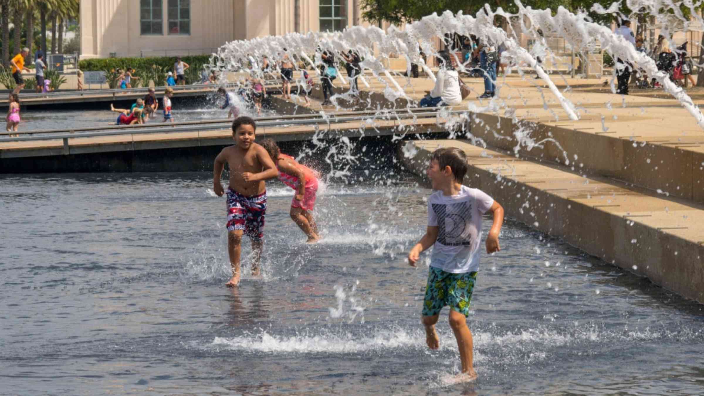 Children playing with water in fountain in Harbour drive in downtown San Diego.