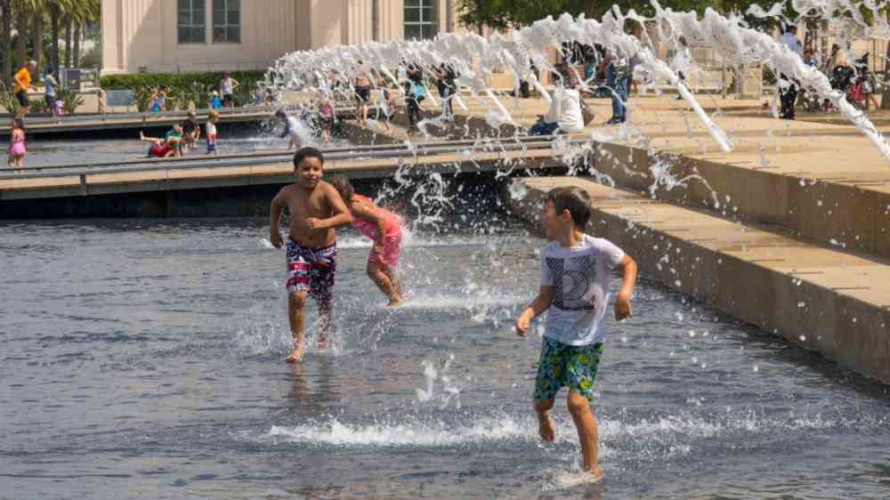 Children playing with water in fountain in Harbour drive in downtown San Diego.