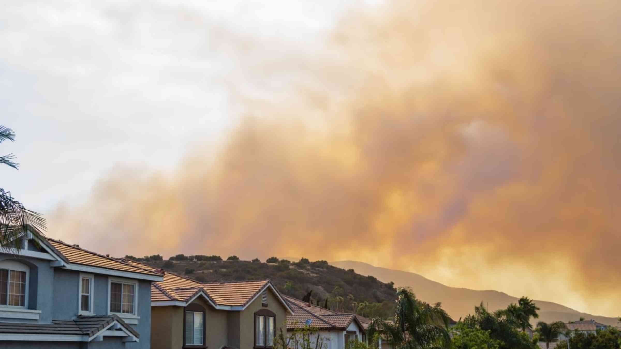 Houses with wildfire smoke in the background