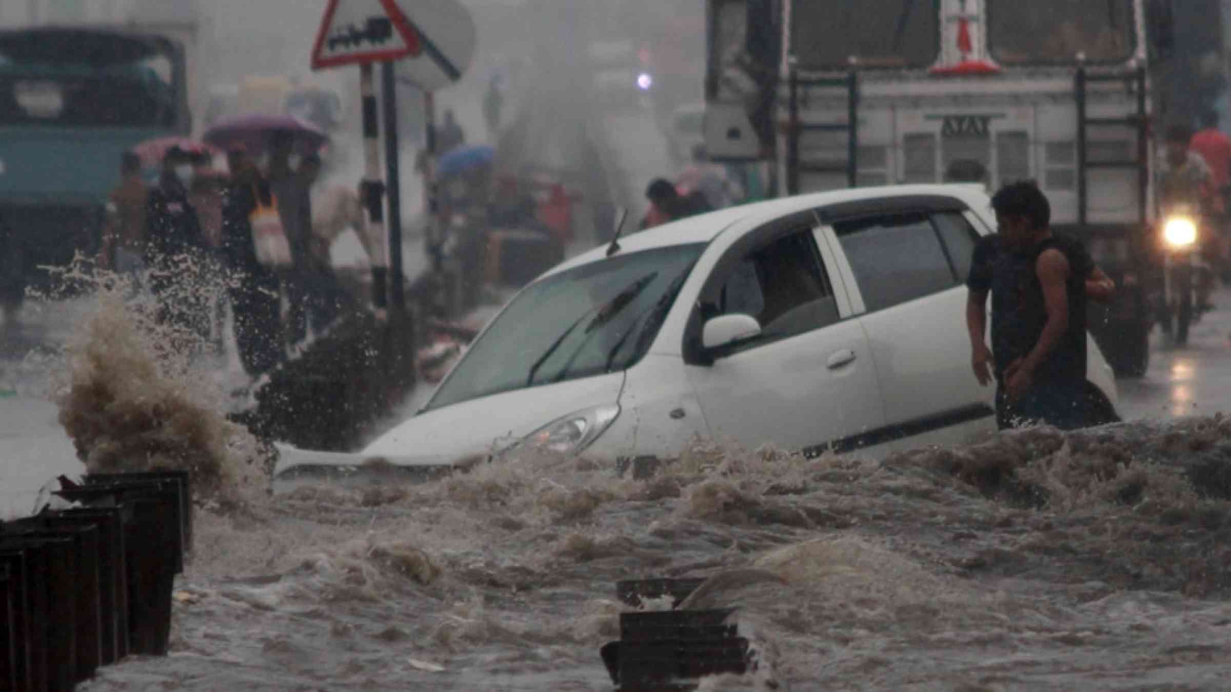 Car submerged by flood waters in a street in India