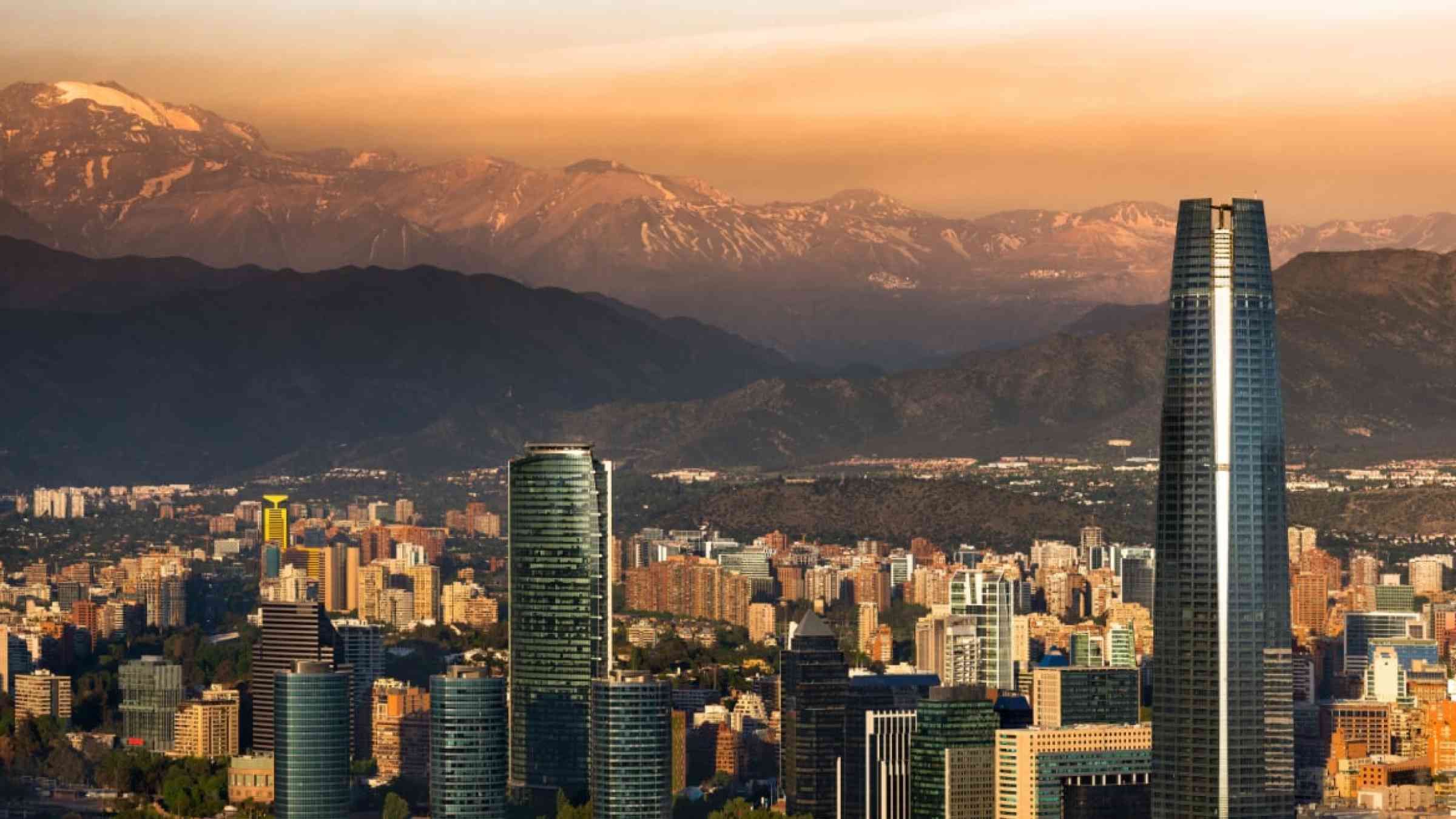 Skyline of Santiago de Chile during sunrise. View of the city and the mountains in the background.