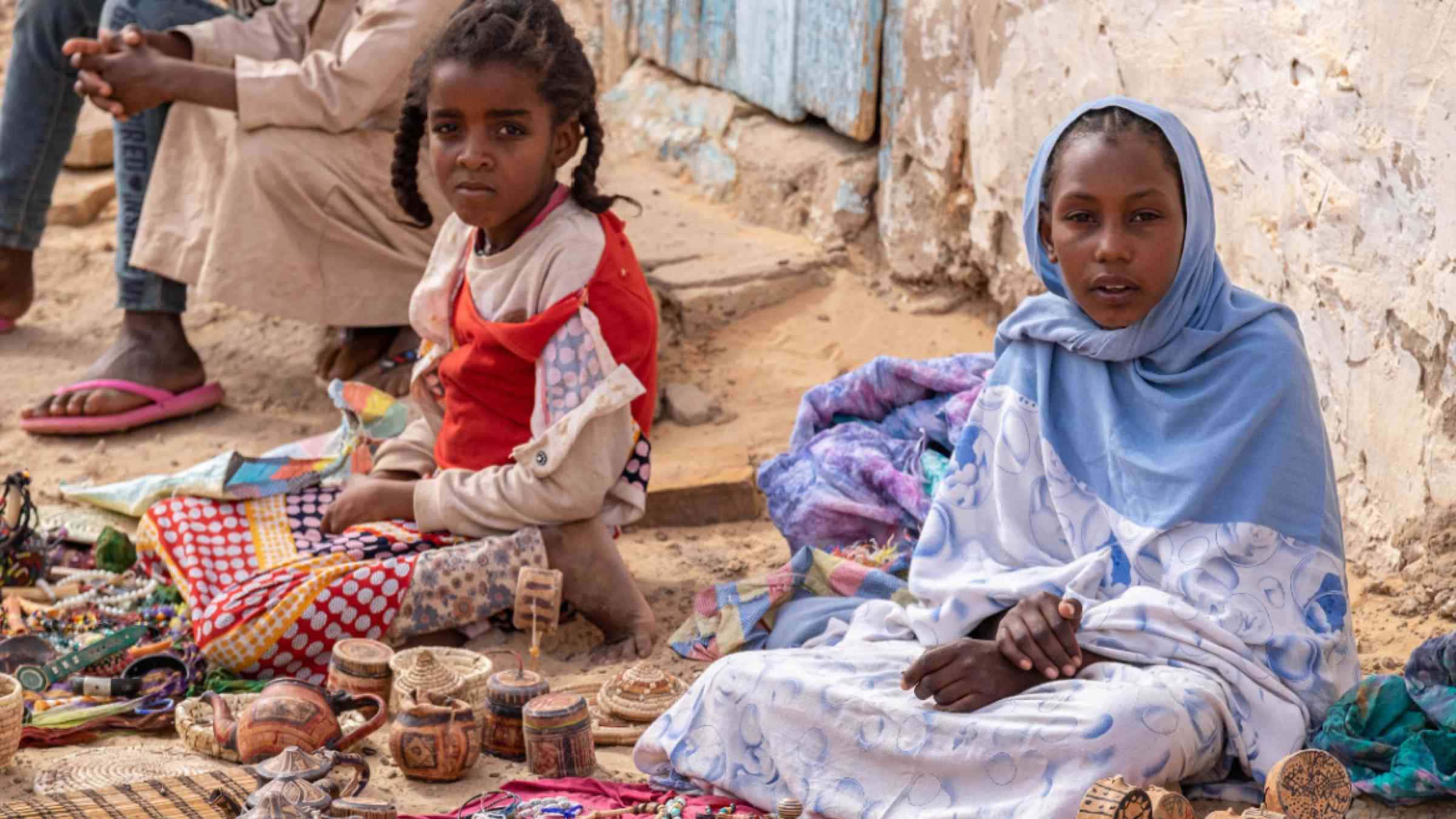 Young woman and a child sitting at a market in Mauritania