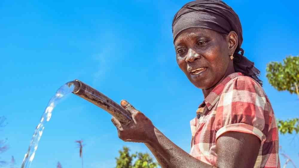 Woman fetching water from a borehole, Nigeria.