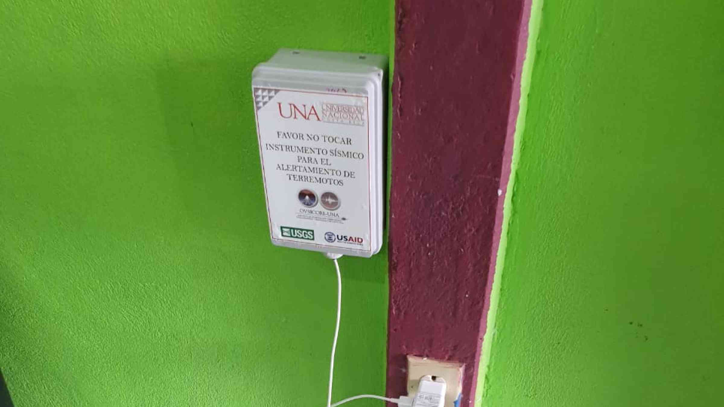   A smartphone for earthquake early warning boxed and plugged in to a wall in Costa Rica. 