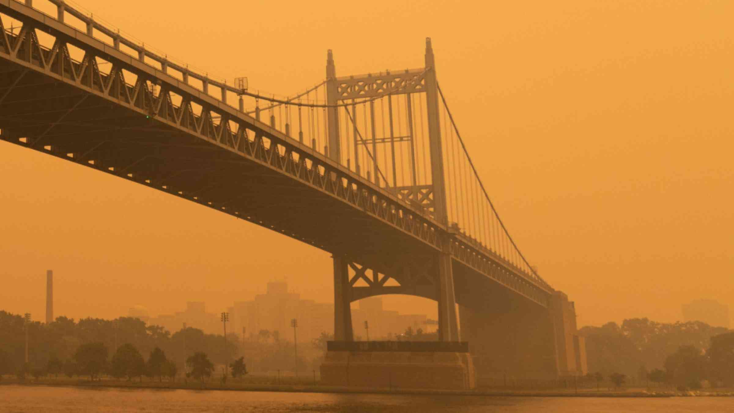 Triborough bridge along the East River in New York City with massive air pollution from wildfire