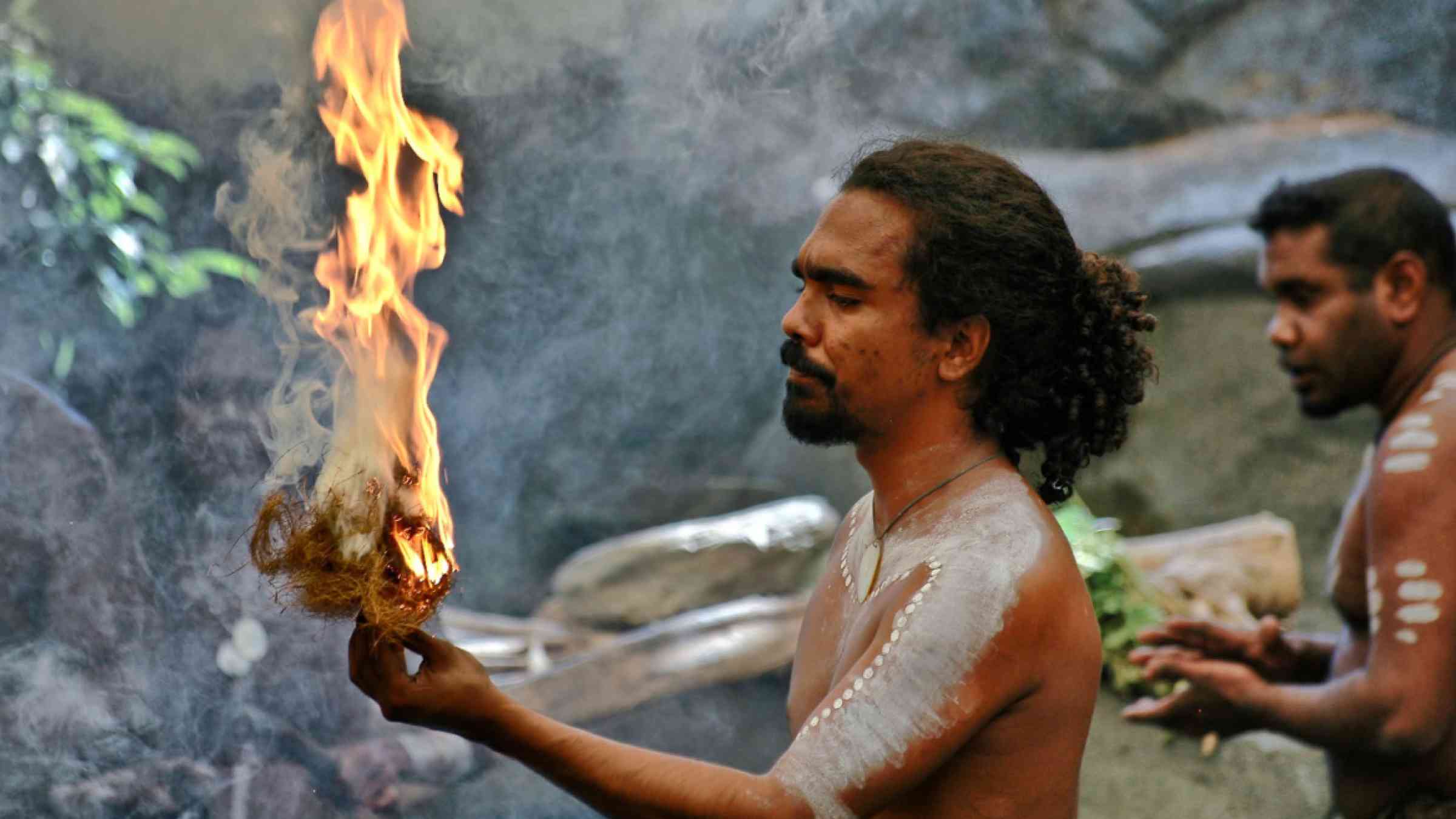 Australian native performing traditional ritual with fire.
