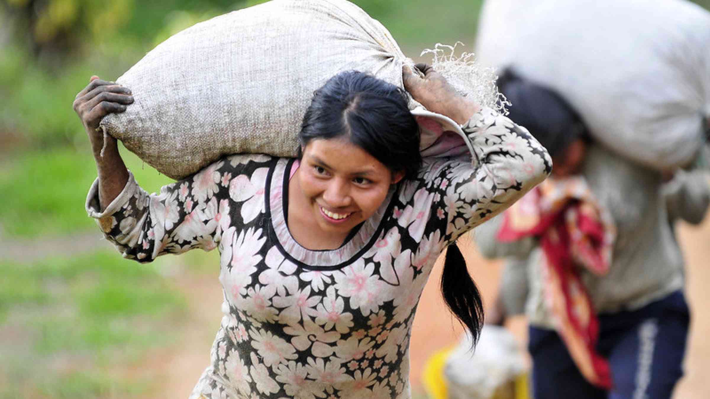 Colombian woman carrying a sack with beans