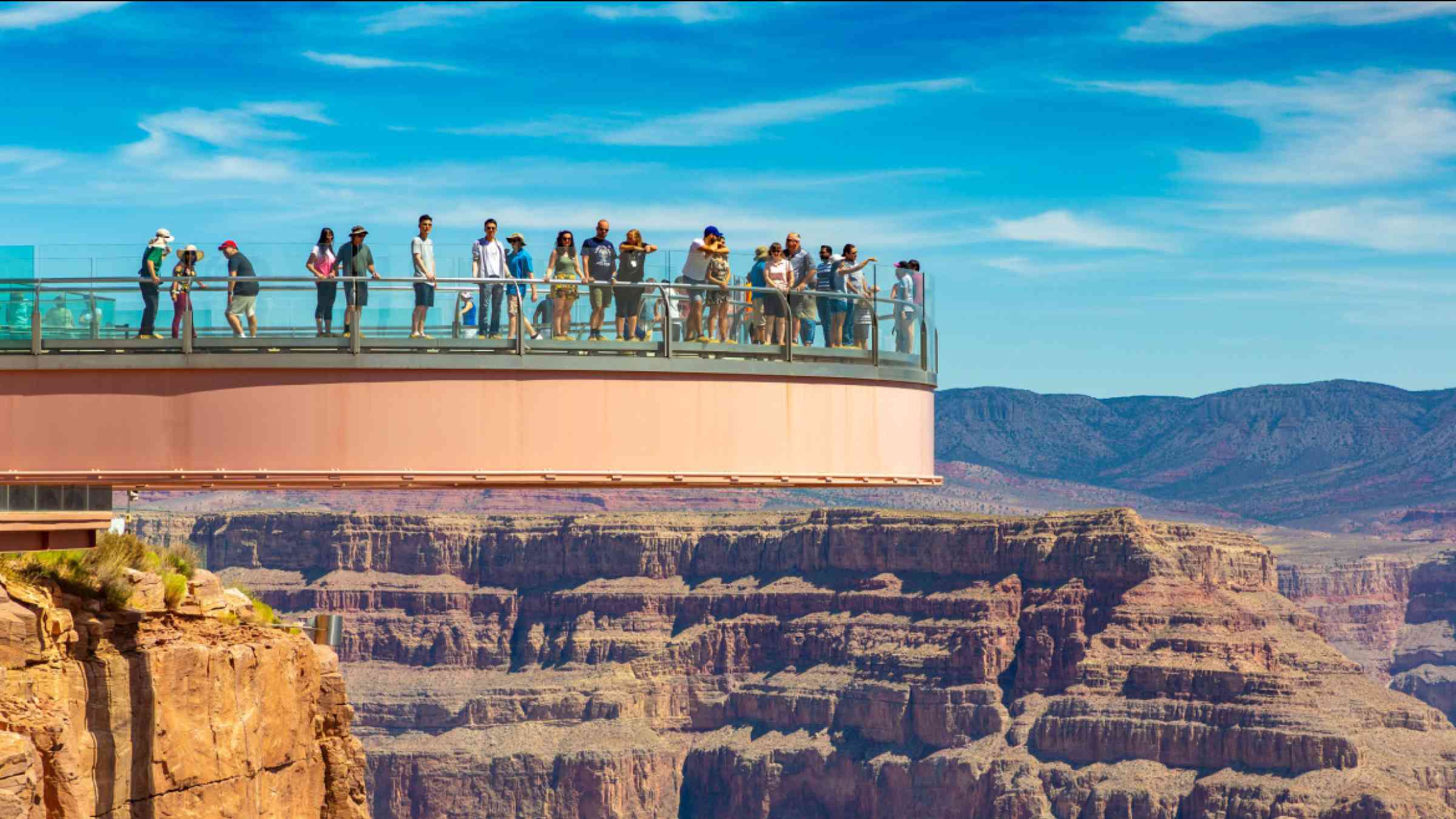 Tourists enjoying the view at Grand Canyon Skywalk observation point at Grand Canyon West Rim in a sunny day, Arizona, USA