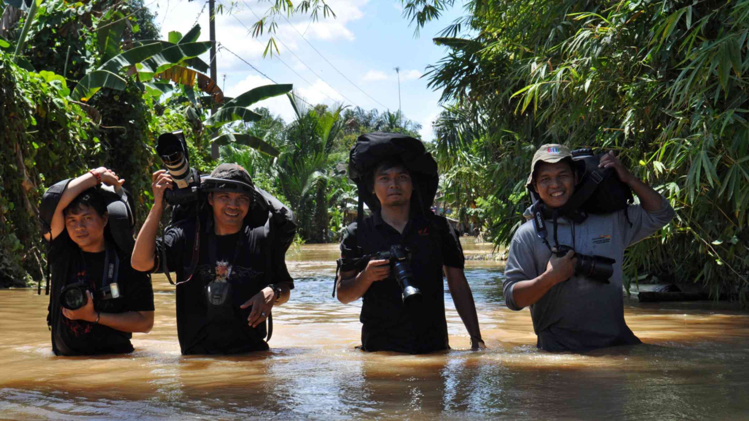 Several photographers break through the flood to cover the flood disaster