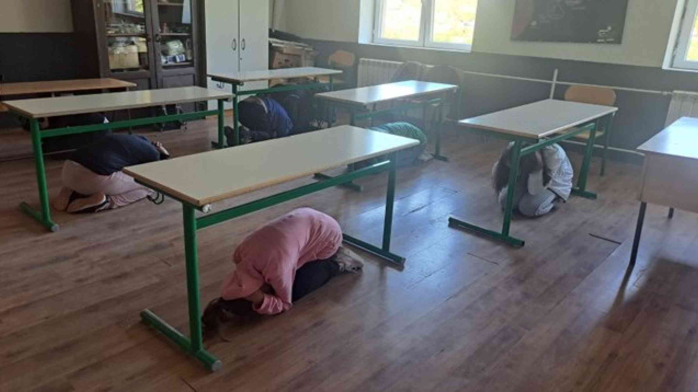 Schoolchildren conducting earthquake drill