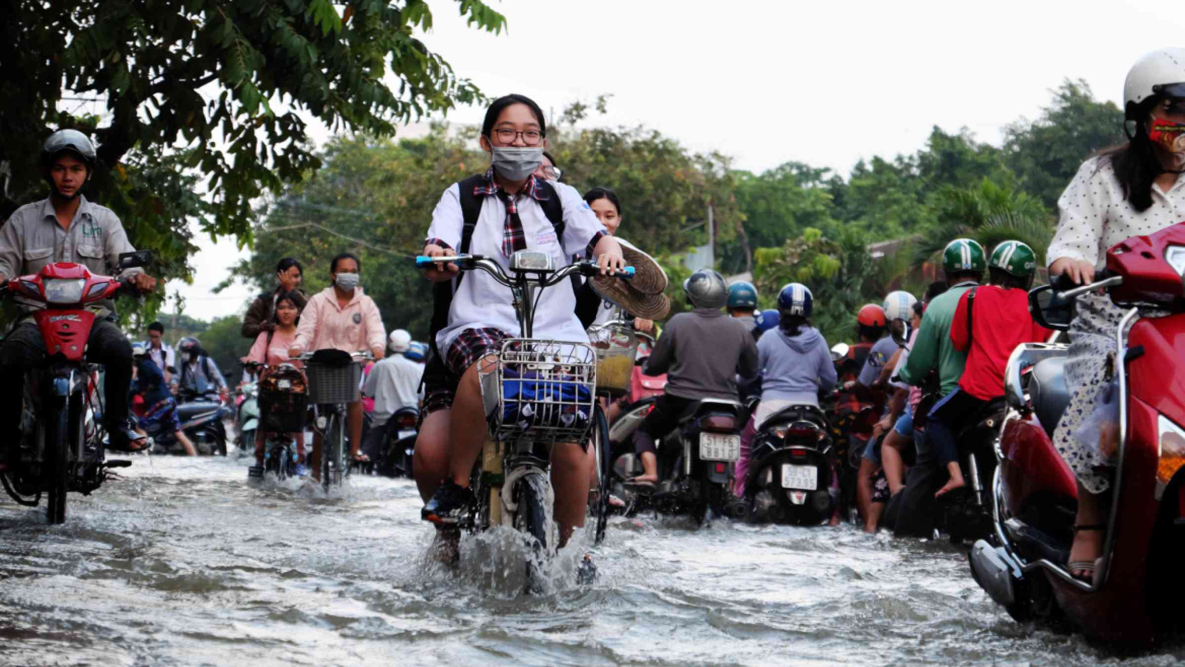 A student rides a bike through the floods in Ho Chi Minh City, Vietnam.
