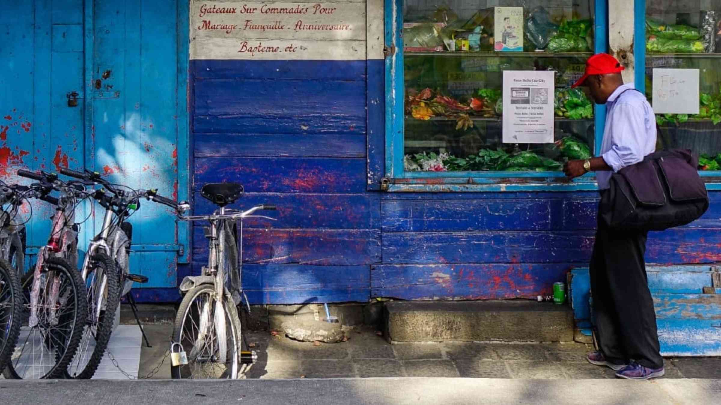 Man standing in front of a grocery store in Port Louis, Mauritius