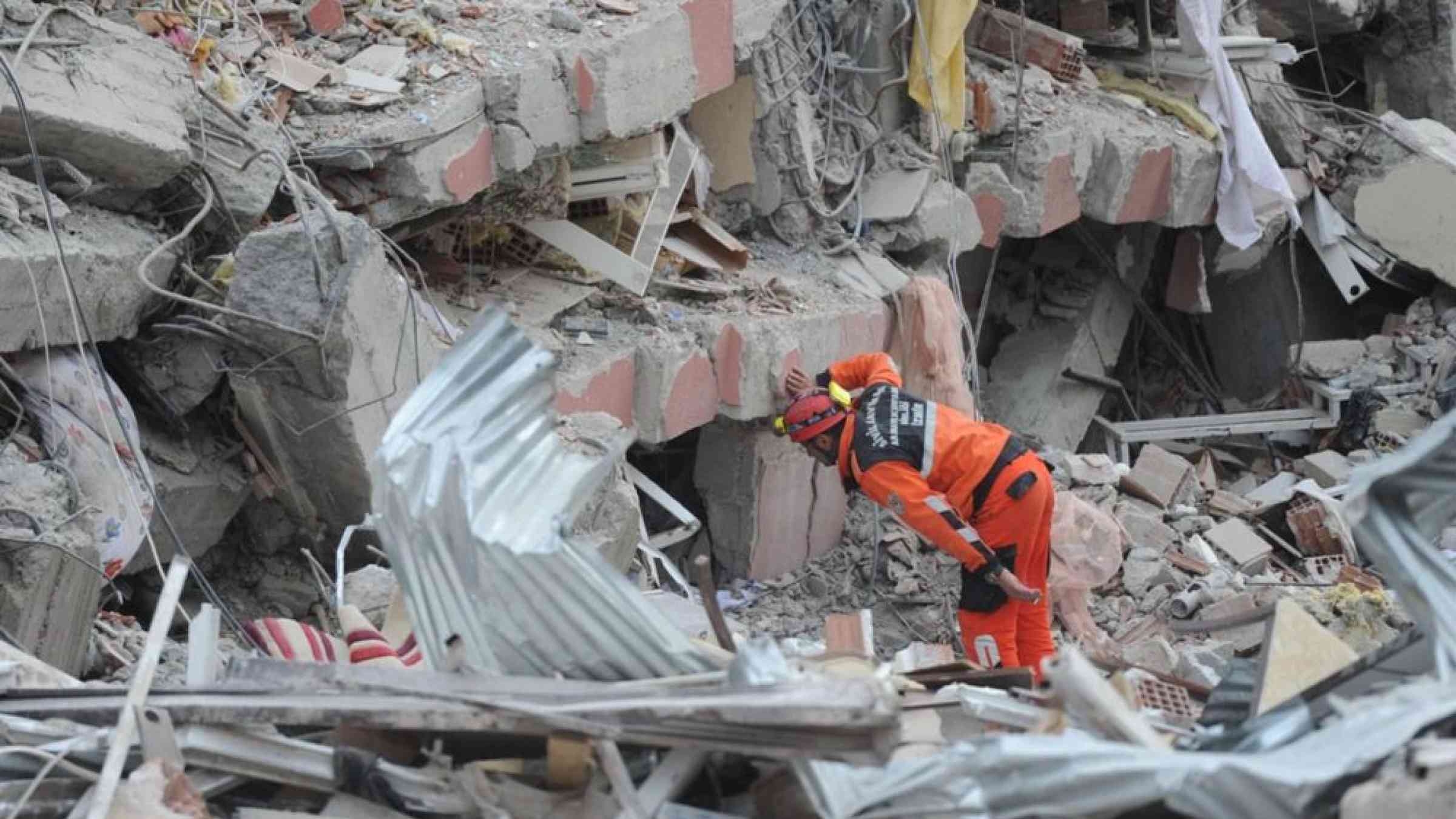 rescue person looking inside a fallen building