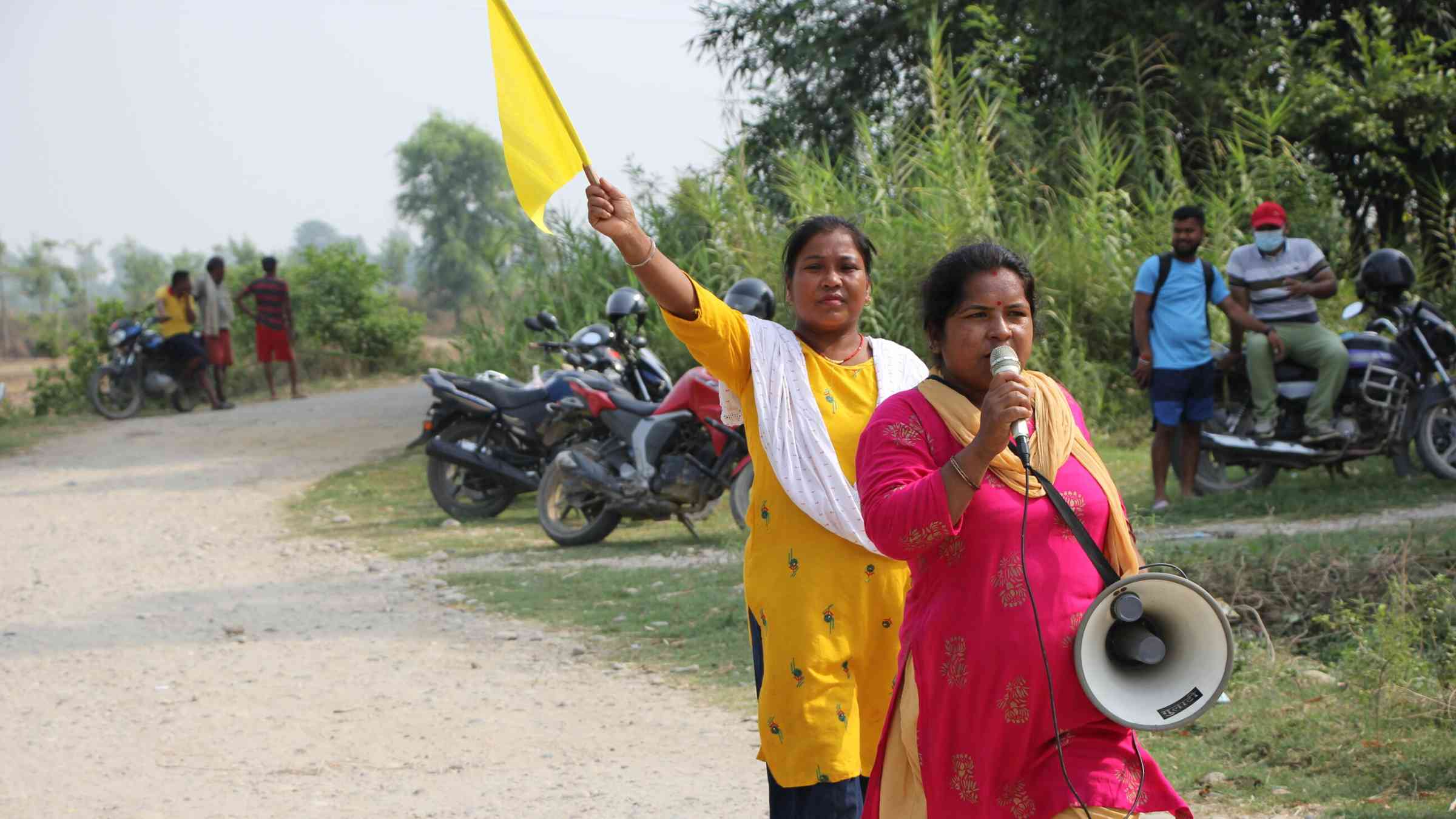 Women in Nepal use a loudspeaker to practise early warnings with local communities.