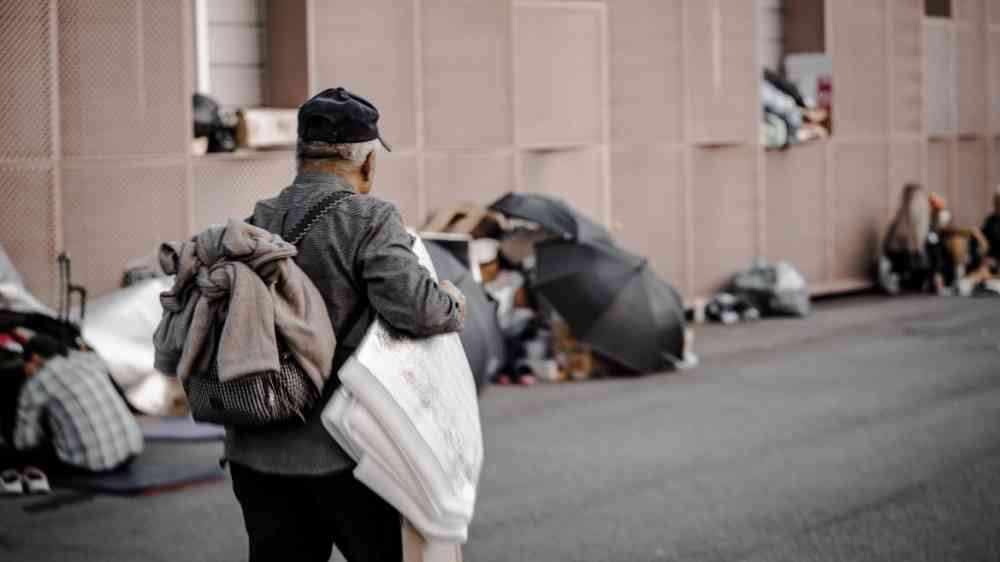 Homeless person walking on front of Seoul Central Station, in South Korea