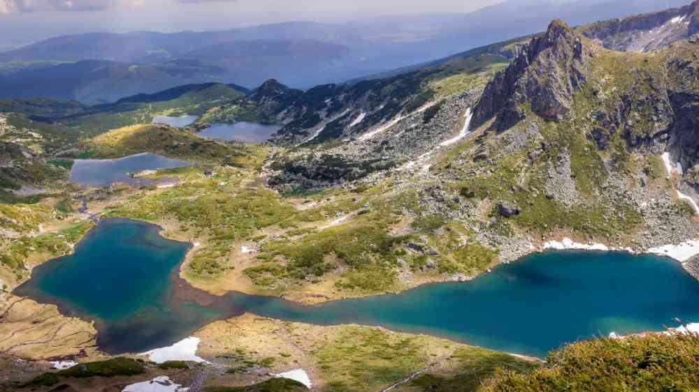 Panoramic, colorful, sunlit view from the Lakes summit on Rila mountain, Bulgaria: The Twin lake, The Trefoil lake, Fish Lake and The Lower lake