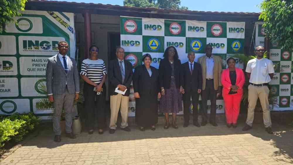 Nine people are gathered for a group photo in front of the official INGD banner