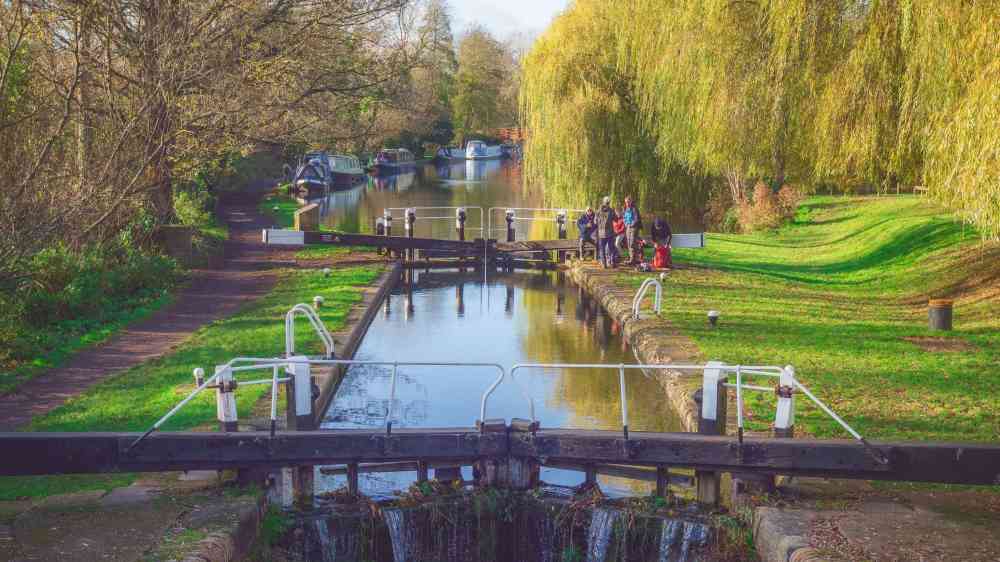 Canal Lock, Grand Union Canal A classic English canal lock on the Grand Union Canal at Berkhamsted, with water cascading gently over the worn wooden gates. 