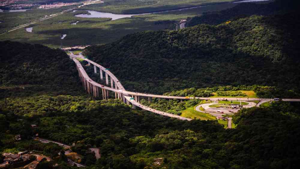 Aerial view of a highway cutting through lush greenery in Santos, São Paulo, Brazil.