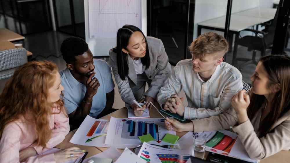 Diverse group of colleagues brainstorming and discussing strategy in a modern office setting.