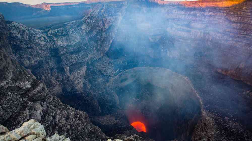 Dramatic aerial view of Masaya Volcano's active crater in Nicaragua emitting smoke and lava.
